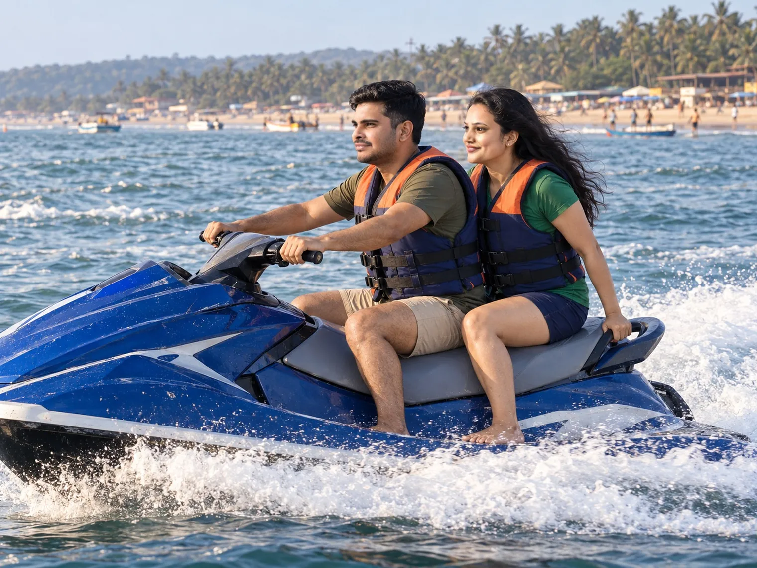 Nav riding a blue jet ski with Vandana behind him, both in life jackets, spray around them and Candolim's beach and palm trees behind.